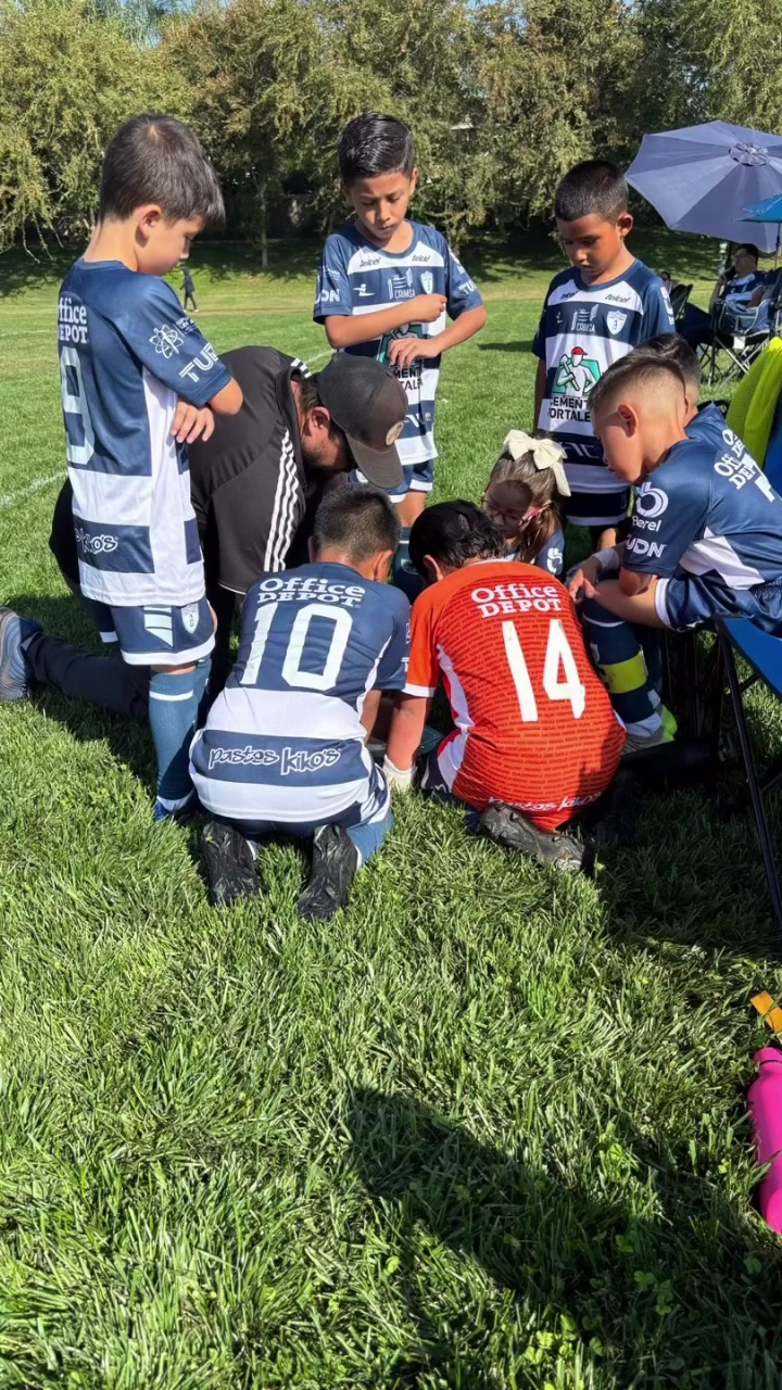 Entrenador acompañando a jugadores de la academia